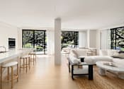 Thumbnail 10 of 24 - A modern living room with white furniture and a marble countertop.