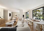 Thumbnail 16 of 24 - A modern living room with a white sofa and wooden furniture.