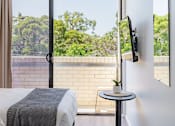 Thumbnail 10 of 11 - a room with a bed and a window with a view of trees