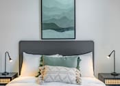 Thumbnail 8 of 11 - a bedroom with a bed with pillows and a painting on the wall