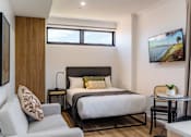 Thumbnail 2 of 11 - a bedroom with a bed and a chair and a table