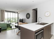 Thumbnail 19 of 19 - a kitchen and living room with a sink and a clock on the wall
