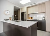 Thumbnail 18 of 19 - a kitchen with a sink and a clock on the wall