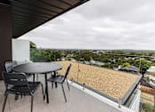 Thumbnail 16 of 19 - a patio with a table and chairs on a balcony