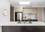 Thumbnail 13 of 19 - a kitchen with a sink and a clock on the wall