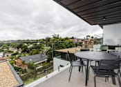 Thumbnail 10 of 19 - a patio with a table and chairs on a balcony