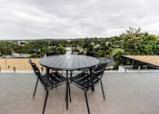 Thumbnail 14 of 19 - a patio with a table and chairs on a roof