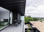 Thumbnail 9 of 19 - a balcony with a table and chairs and a view of the city