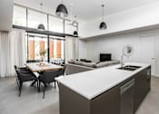 Thumbnail 1 of 19 - a kitchen and living room with an island and a table with chairs