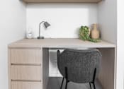 Thumbnail 4 of 19 - a desk and a chair in a room with wooden cabinets