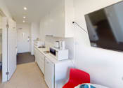 Thumbnail 11 of 11 - a small kitchen with a microwave and a refrigerator