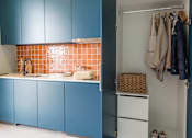 Thumbnail 8 of 11 - a kitchen with blue cabinets and a refrigerator and a closet