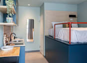 Thumbnail 4 of 11 - a bunk bed in a room with a kitchen and a sink