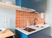 Thumbnail 5 of 11 - a kitchen with blue cabinets and a sink and a counter top