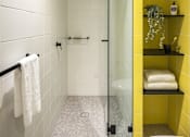 Thumbnail 9 of 12 - a bathroom with yellow tiles and a glass shower door