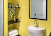 Thumbnail 10 of 12 - a yellow bathroom with a sink and a mirror