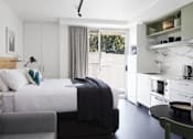 Thumbnail 11 of 13 - a hotel room with a bed and a couch and a kitchen