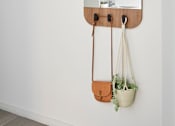 Thumbnail 5 of 10 - a mirror hanging on a wall with two hanging bags