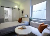 Thumbnail 6 of 11 - a small room with a bed and a small table