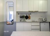 Thumbnail 5 of 11 - a kitchen with white cabinets and a mirror on the wall