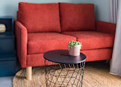 Thumbnail 9 of 11 - a living room with a red couch and a round table