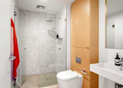 Thumbnail 5 of 22 - a bathroom with a shower and a wooden floor and white walls