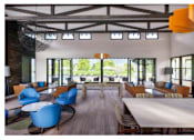 Thumbnail 10 of 11 - Clubhouse has leather chair and sofas, and a large table.