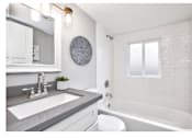 Thumbnail 7 of 11 - Modern bathroom interior with white vanity topped with gray countertop