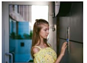 Thumbnail 4 of 11 - A women trying to open the apartment door with a controlled access system