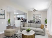 Thumbnail 1 of 21 - A living room with a grey couch, a coffee table, and a ceiling fan.