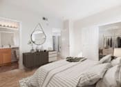 Thumbnail 20 of 21 - A bedroom with a large bed and a vanity with a mirror.