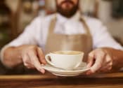 Thumbnail 4 of 4 - a barista holding a cup of coffee