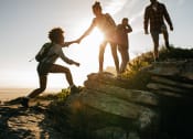 Thumbnail 2 of 4 - a group of people hiking up a mountain holding hands