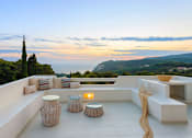 Thumbnail 2 of 6 - A patio with a table and chairs overlooking a scenic view.