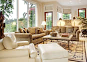 Thumbnail 1 of 6 - A living room with a large window and a view of trees.