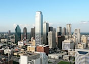 Thumbnail 6 of 6 - A cityscape with a variety of buildings, including a tall skyscraper with a pointed top.