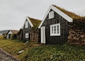 Thumbnail 4 of 6 - A small house with a grass roof sits in a field.