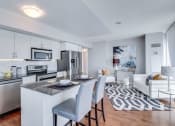 Thumbnail 1 of 8 - a kitchen and living room with white cabinets and a black and white rug