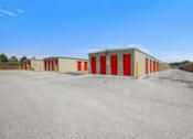 Thumbnail 12 of 13 - a row of garages with red doors in a parking lot
