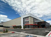Thumbnail 1 of 13 - a building with a parking lot in front of it