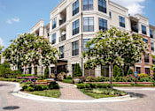 Thumbnail 16 of 20 - A large building with a lot of windows and trees in front.