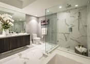 Thumbnail 5 of 7 - A bathroom with a walk-in shower and a toilet.