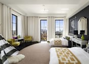 Thumbnail 3 of 7 - A bedroom with a large bed and a yellow chair.