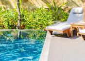 Thumbnail 6 of 20 - A poolside lounge chair with a white cushion and wooden frame at Bluebell Ridge, Denver CO 80202