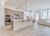 Thumbnail 8 of 20 - A modern kitchen with a white island and a refrigerator on the left at Bluebell Ridge, Colorado 80202