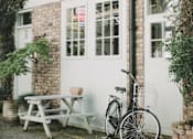 Thumbnail 1 of 5 - A bicycle is parked next to a white door.