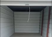 Thumbnail 11 of 22 - the inside of a garage with a white floor and a door