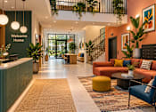 Thumbnail 2 of 6 - A welcoming home interior with a green reception desk and a variety of seating options.