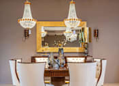 Thumbnail 2 of 10 - A dining room with a large table and chairs.