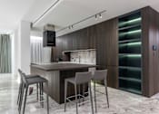 Thumbnail 19 of 21 - A modern kitchen with a bar area and grey chairs.